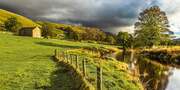Fields and stone barn alongside the River Wharfe near Kettlewell, Wharfedale, Yorkshire Dales, England.
