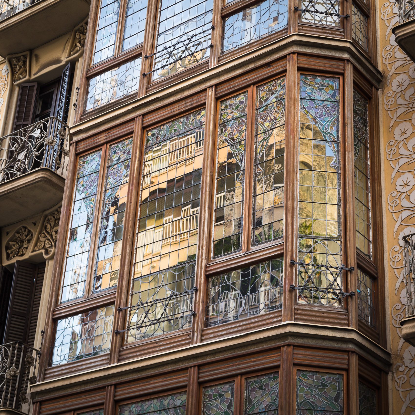 Modernista style window facade in Barcelona Spain, with reflection of buildings opposite. BC006