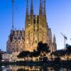 Dusk view of  the Nativity Facade of La Sagra Familia basilica reflected in the lake of the Placa de Gaudi, Barcelona, Spain.