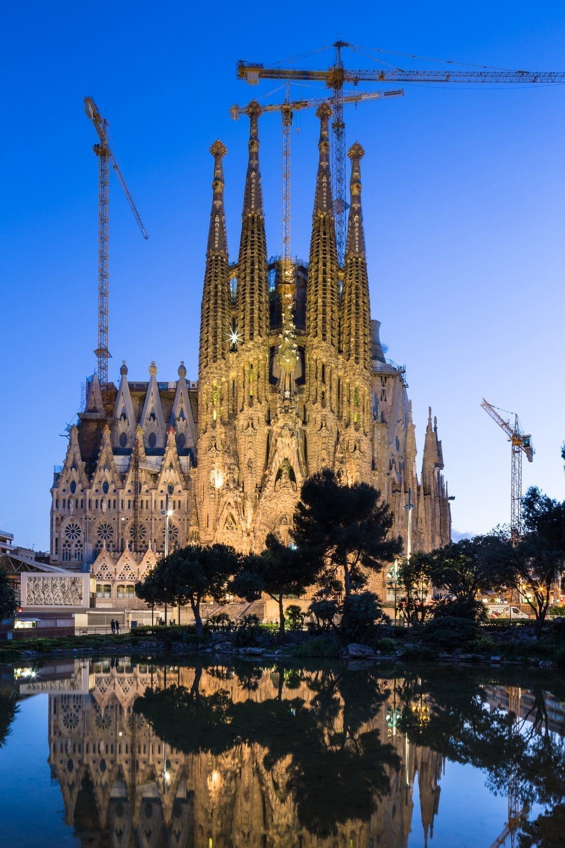 Dusk view of  the Nativity Facade of La Sagra Familia basilica reflected in the lake of the Placa de Gaudi, Barcelona, Spain.