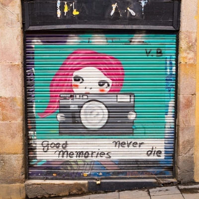 Painted roller door with tag 'Good Memories Never Die' in Barcelona, Spain.