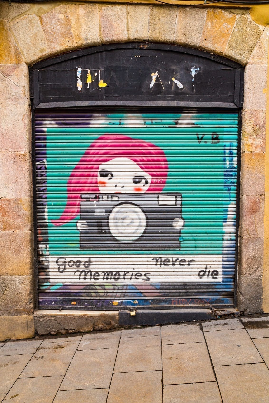 Painted roller door with tag 'Good Memories Never Die' in Barcelona, Spain.