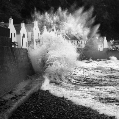 Wave breaking against the sea wall at Pennan on the Moray Coast, Scotland.