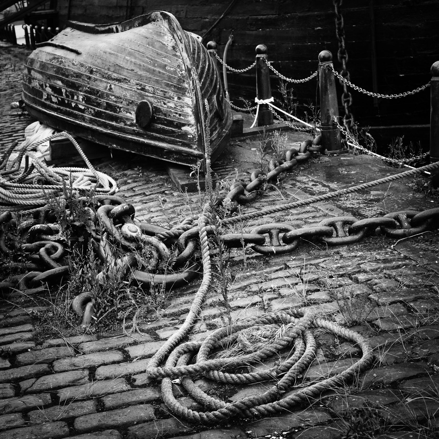 Monochrome (black and white) image of upturned small boat and rope on Victoria Dock, Dundee, Scotland. DD006