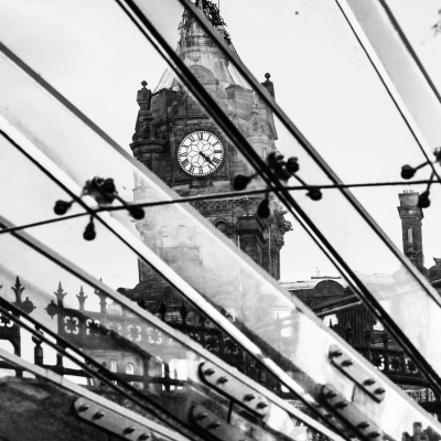 Monochrome (black and white) image of the Balmoral Hotel seen through the Waverley Mall entrance canopy, Edinburgh, Scotland, United Kingdom.
