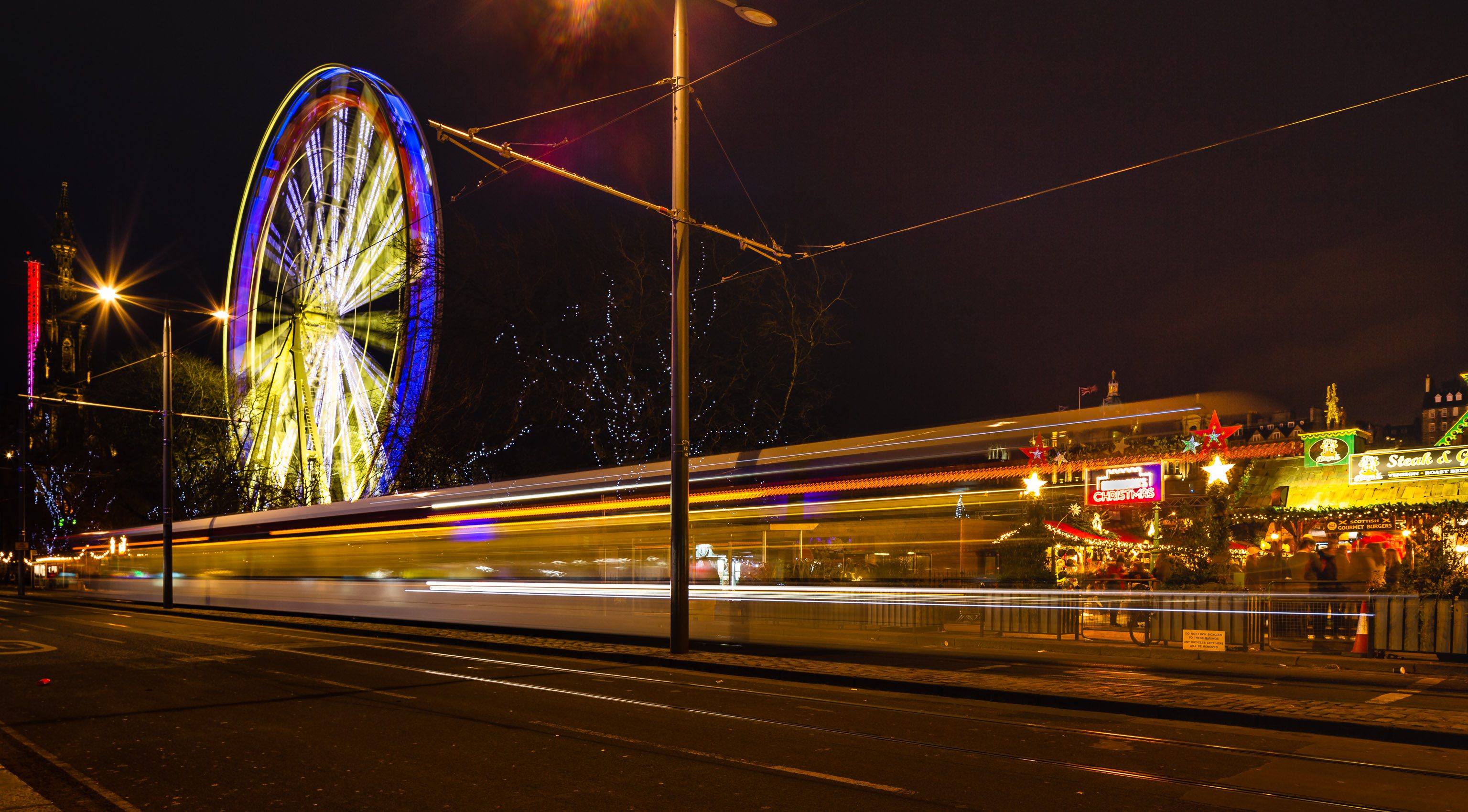Light trails and a giant Ferris Wheel in Princes Street, Edinburgh, Scotland. EH012