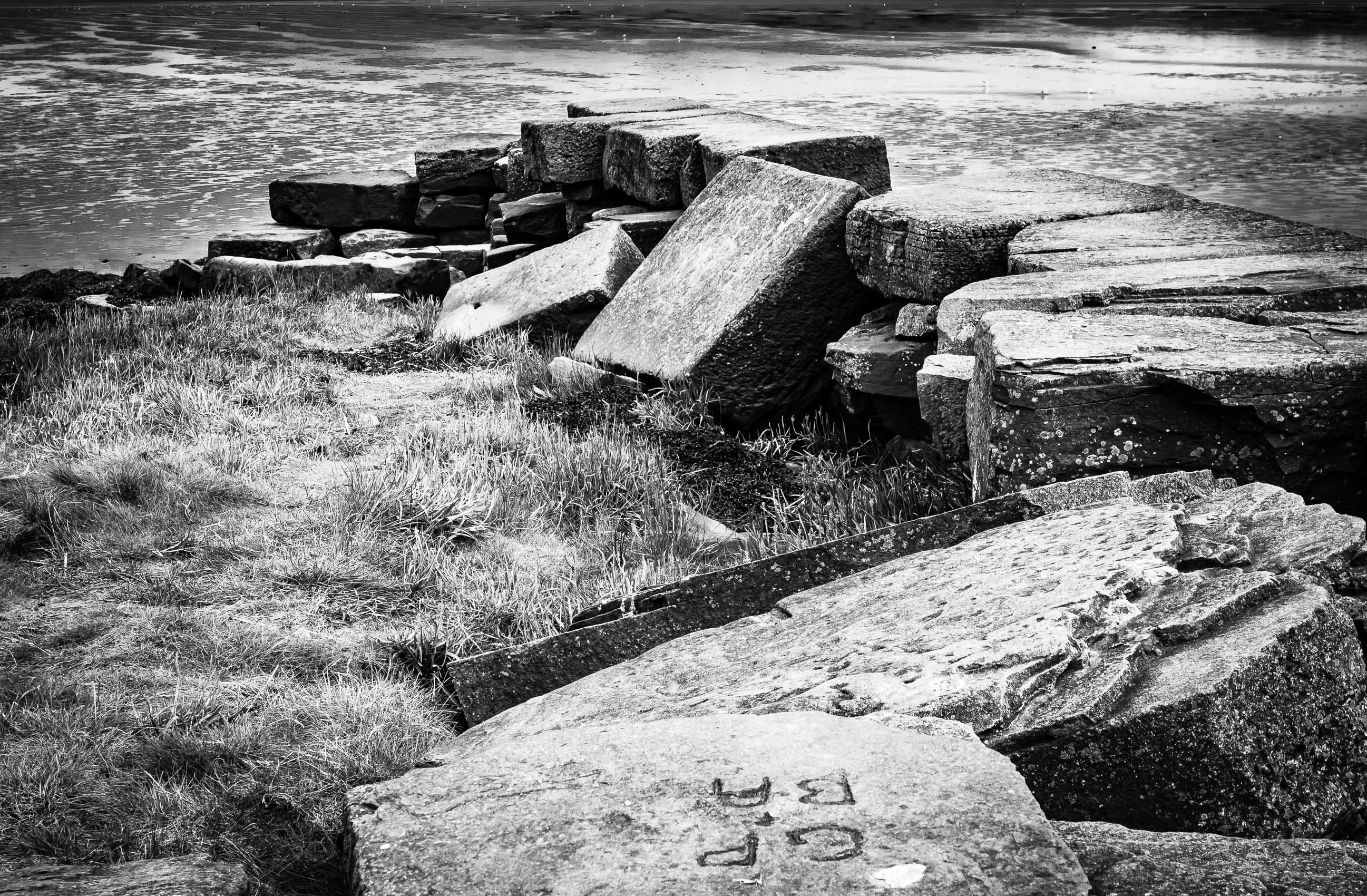 Monochrome (black and white) image of derelict stone pier at Invergowrie, Scotland. DD104