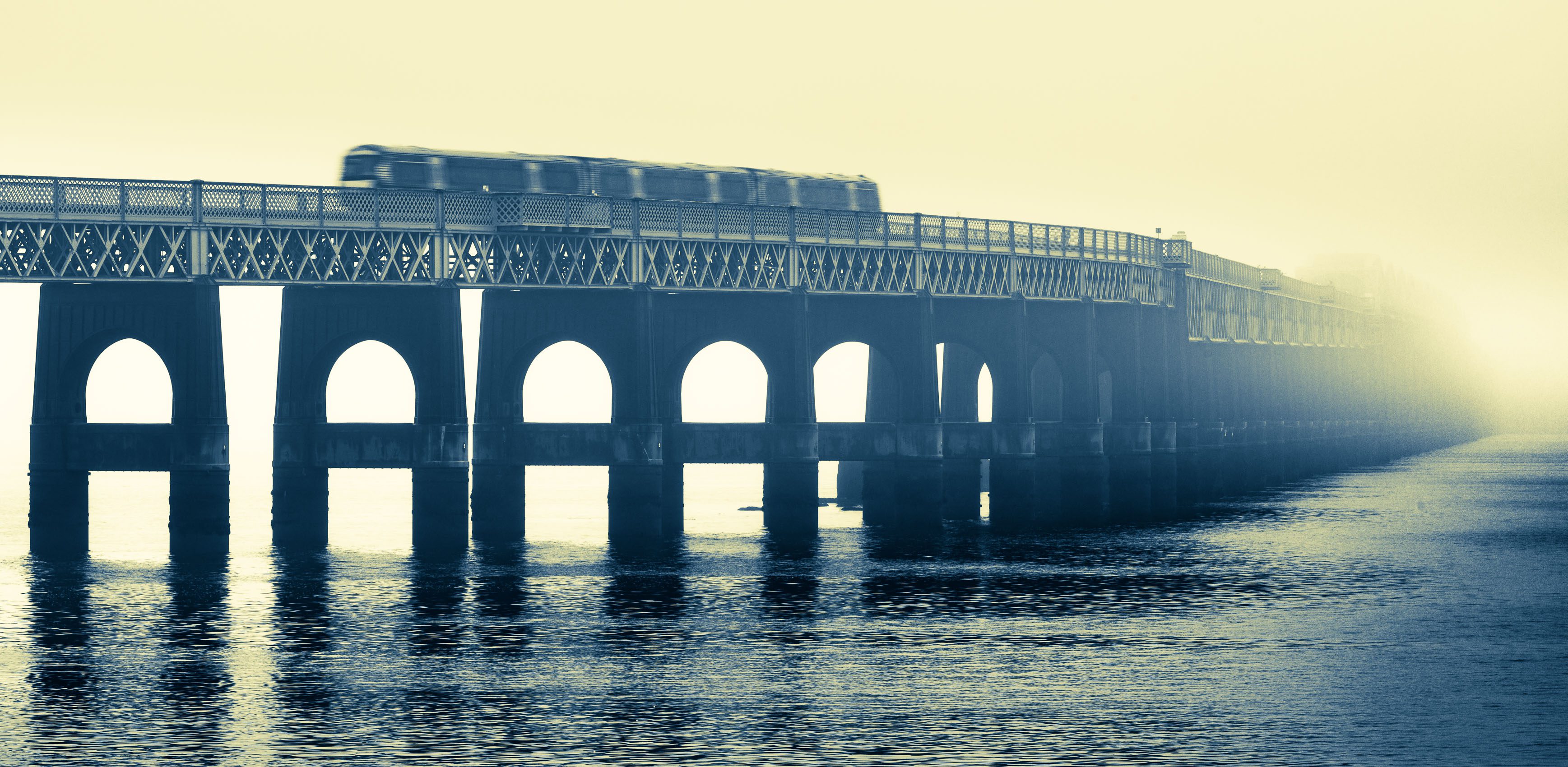 Duotone image of the Tay Railway Bridge as a train passes over, Dundee, Scotland. DD079