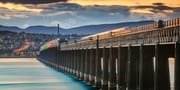 Train crossing the Tay Bridge at dusk, Wormit, Fife, Scotland.