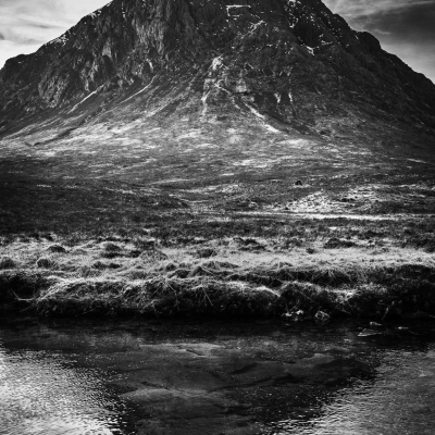 Buachaille Etive Mor casts a shadow in the River Coupall, Rannoch Moor, Scotland.