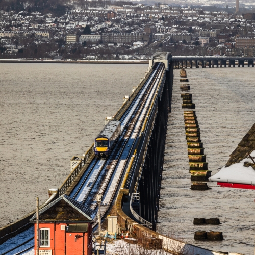 Train crossing the Tay Rail Bridge in wintry conditions from Wormit, Fife, Scotland. DD109