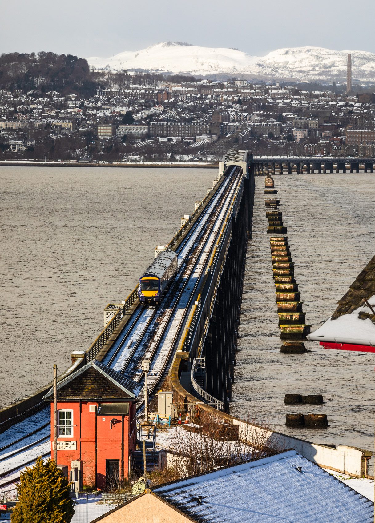Train crossing the Tay Rail Bridge in wintry conditions from Wormit, Fife, Scotland. DD109