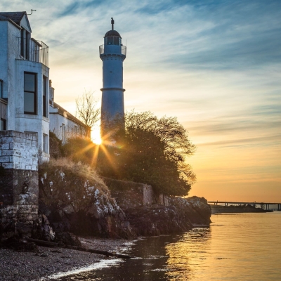 Sun setting behind Tayport West Lighthouse on the Firth of Tay, Fife, Scotland