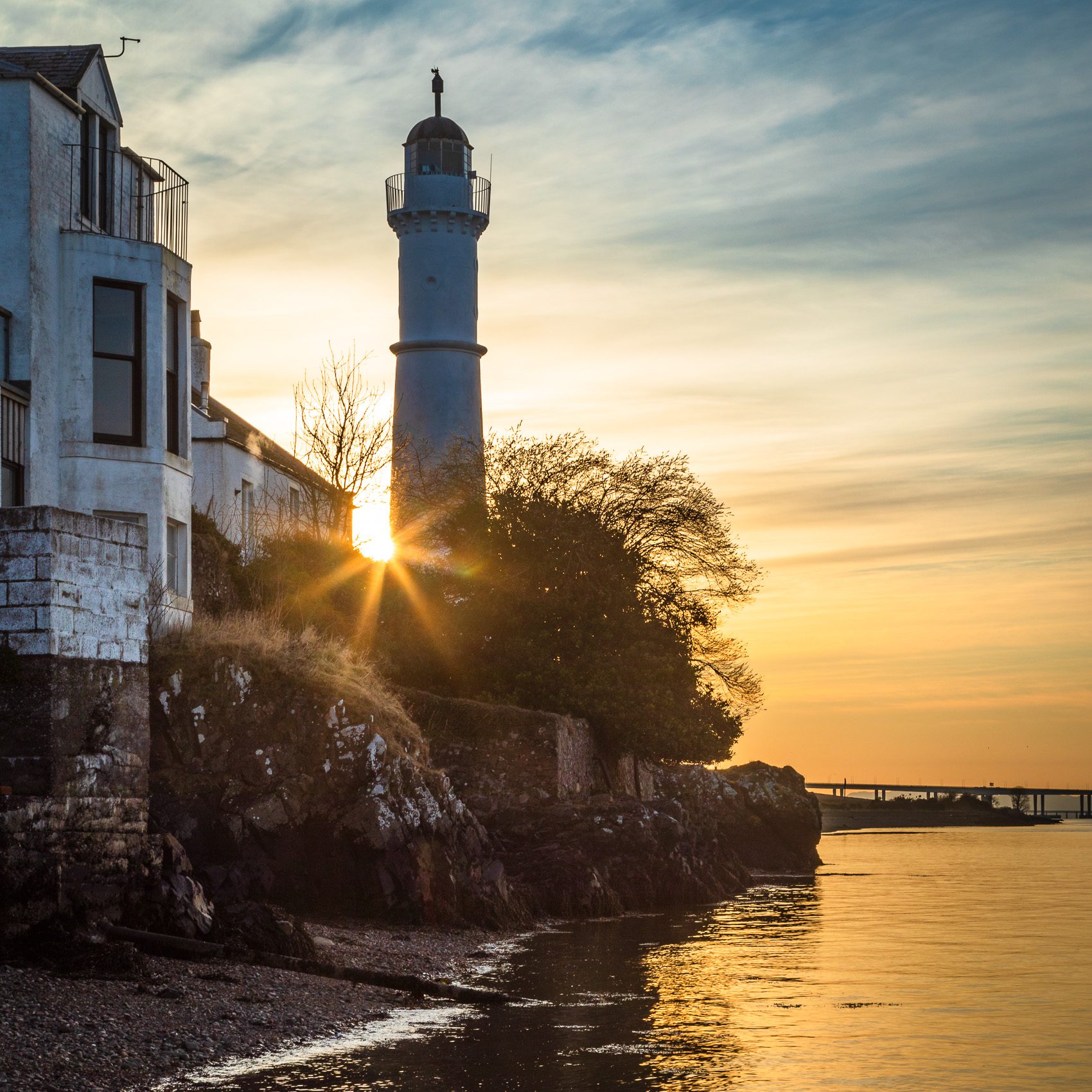 Sun setting behind Tayport West Lighthouse on the Firth of Tay, Fife, Scotland RT003