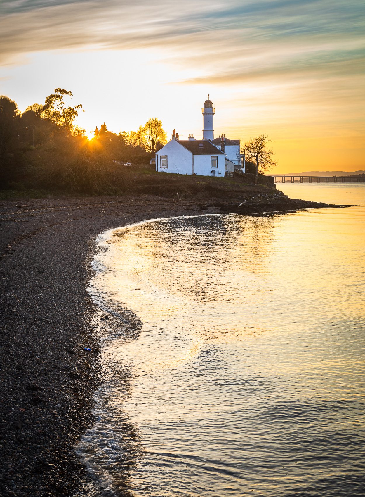 Sun setting behind Tayport West Lighthouse on the Firth of Tay, Fife, Scotland RT004