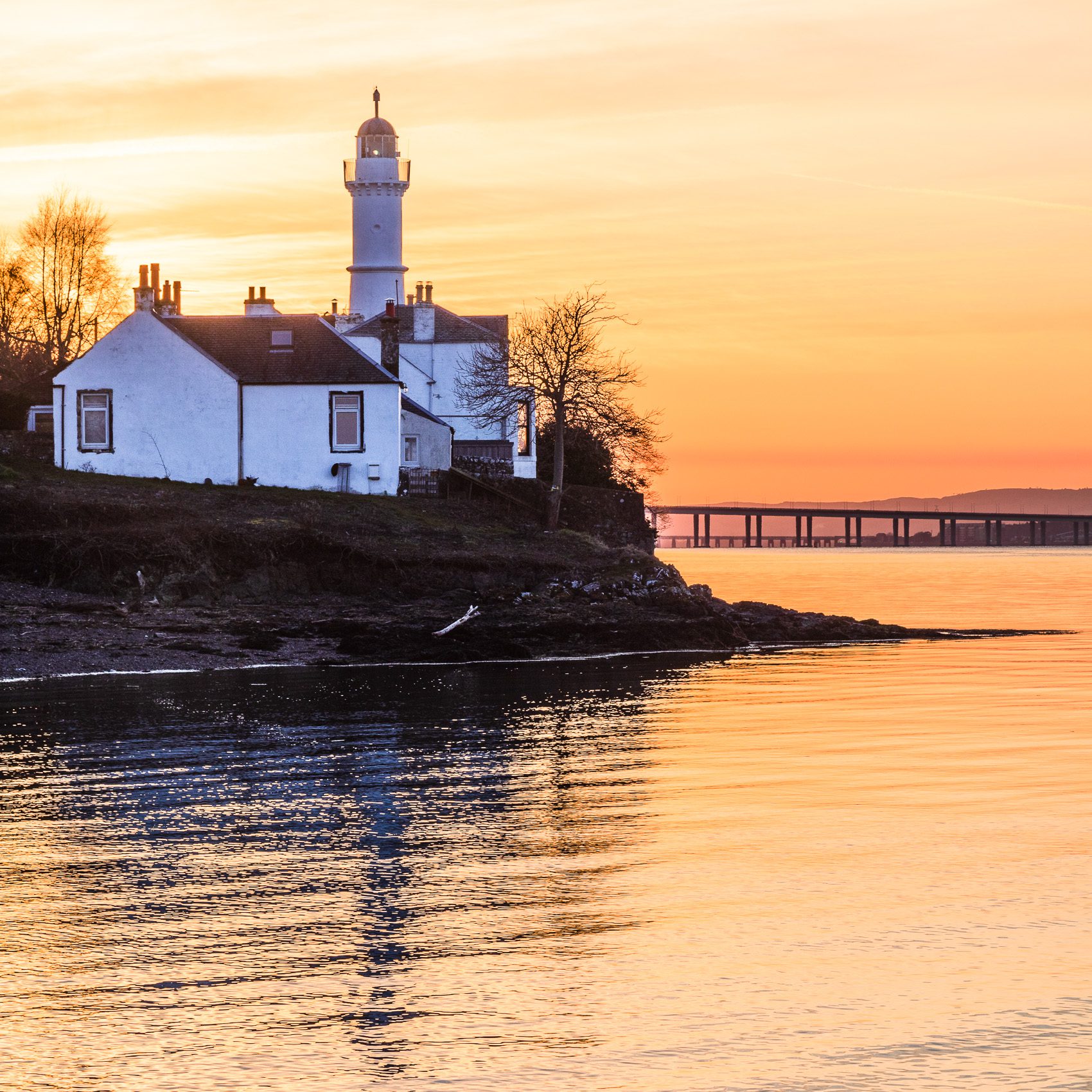 Sun setting behind Tayport West Lighthouse on the Firth of Tay, Fife, Scotland RT006