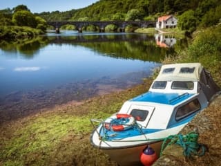 Cabin cruiser beached by the old quay on the River Blackwater at Cappoquin, County Waterford, Ireland. BW021